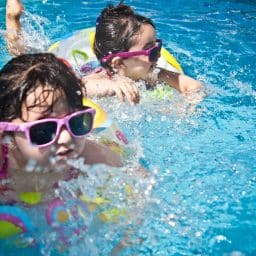 Two little girls swimming in a pool.
