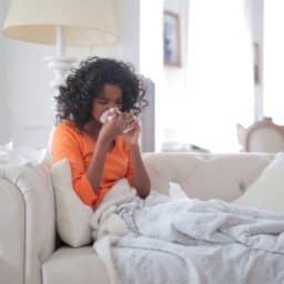 Woman sick on her couch with a sinus infection.