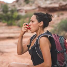 Woman uses inhaler on hike