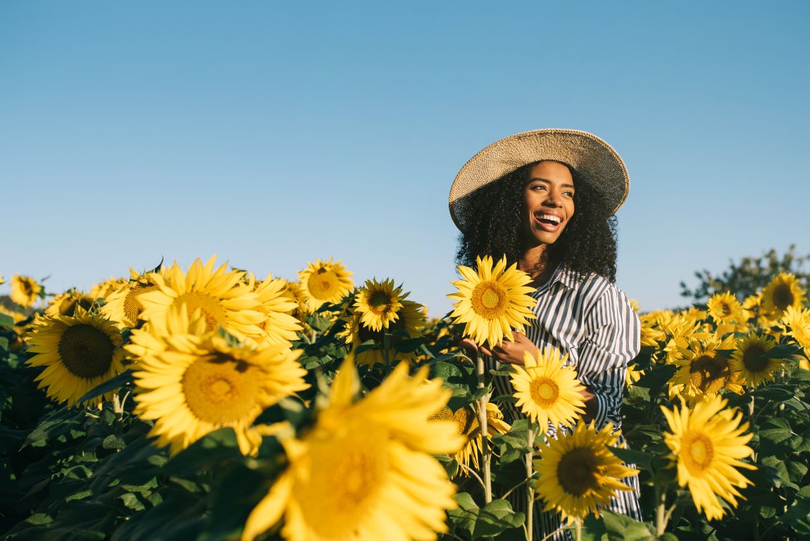 Rhinitis Sufferer woman smiling in field of sunflowers