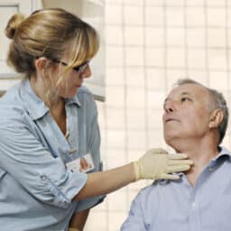Healthcare worker checking man's throat