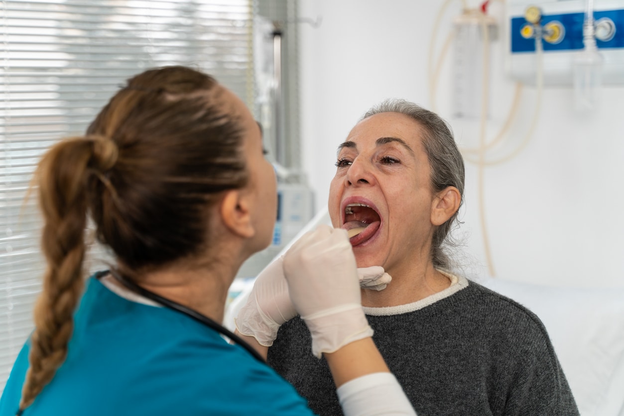 ENT examining a patient's throat.