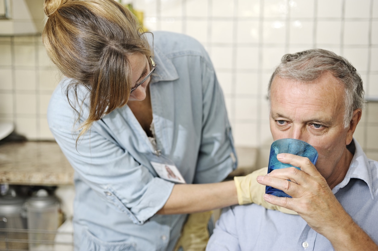 Healthcare worker checking man's throat.
