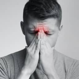 Man holding his nose because sinus pain