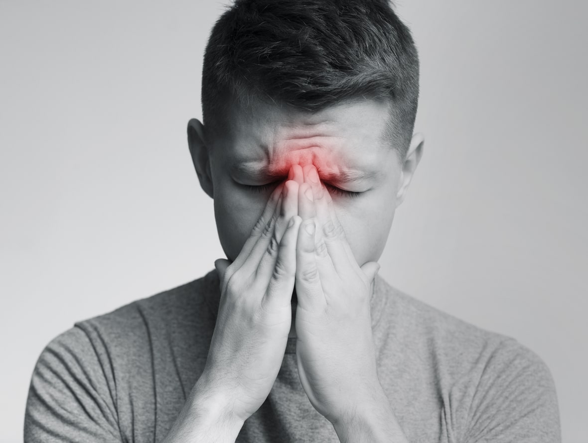 Man holding his nose because sinus pain.