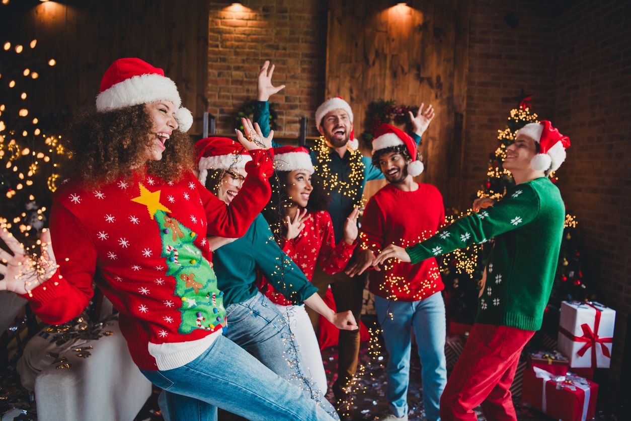 Happy group of friends dancing at a holiday party.