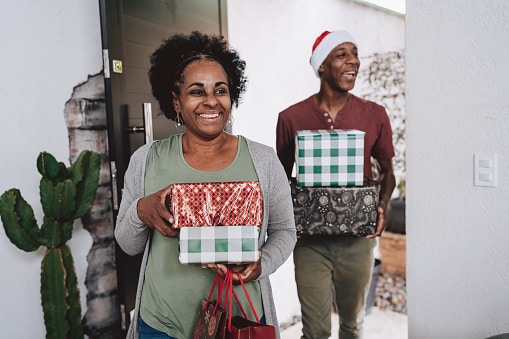 Two people carrying wrapped presents.
