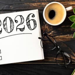 New year resolutions 2026 on desk. 2026 goals list with notebook, coffee cup, plant on wooden table. Resolutions, plan, goals, action, checklist, idea concept. New Year 2026 resolutions.