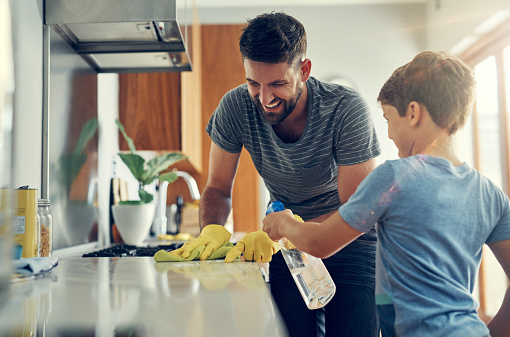 Father and son cleaning the kitchen.