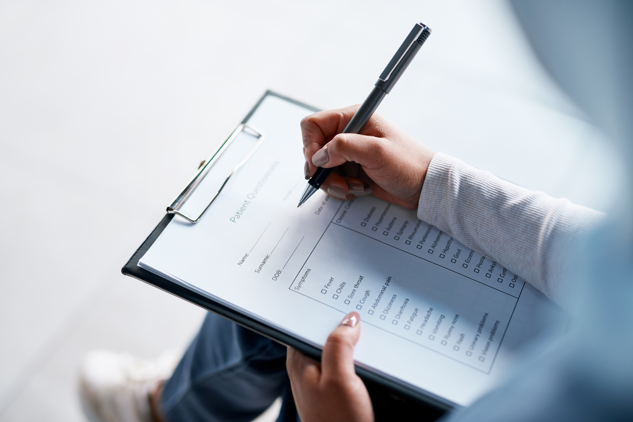Woman filling out a healthcare questionnaire at the doctor's office.