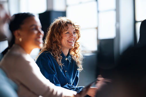 Two cheerful coworkers share ideas in a vibrant office setting.